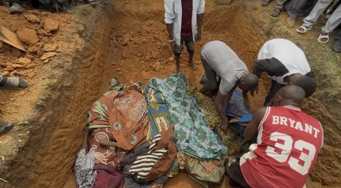 IMAGE 1 Locals arrange bodies of seven victims in a shallow grave